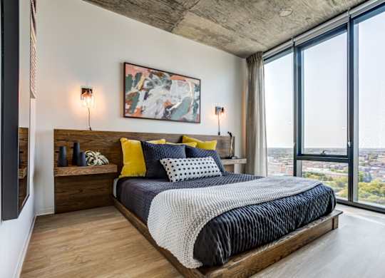 A bedroom with a large bed and a view of the city.