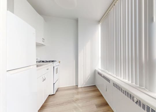 A white kitchen with a stove, oven, and cabinets.
