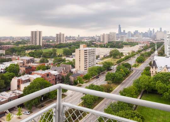 A cityscape with a cloudy sky and a highway in the foreground.