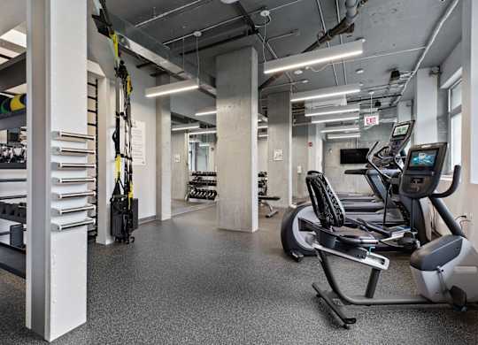 A gym with treadmills, exercise bikes, and other equipment.