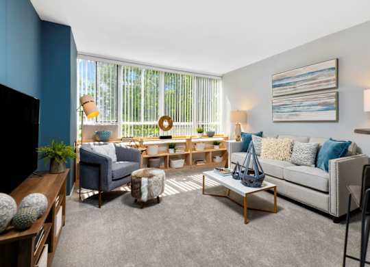 A living room with a grey sofa, a wooden coffee table, and a painting on the wall.