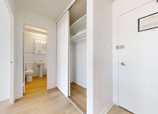 A white bathroom with a toilet, sink, and mirror.