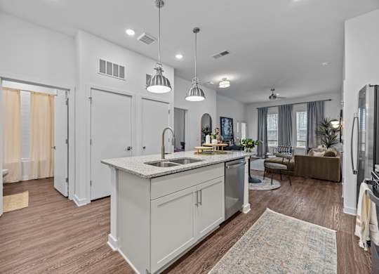 A modern kitchen with a large island and pendant lights.at Address East End, North Carolina