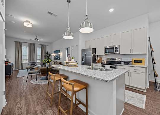 A kitchen with a white countertop and wooden bar stools.at Address East End, Raleigh, 27610