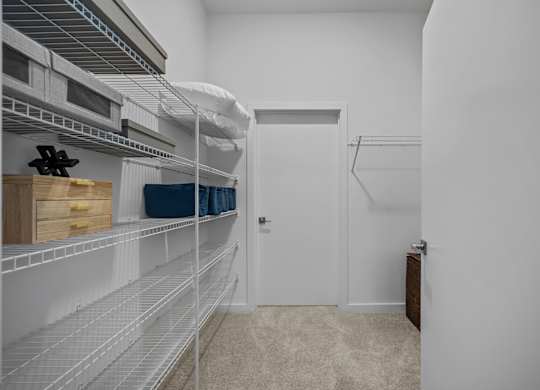A white pantry with a door and shelves.at Address East End, Raleigh, 27610