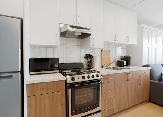 A modern kitchen with a stove, oven, and refrigerator.