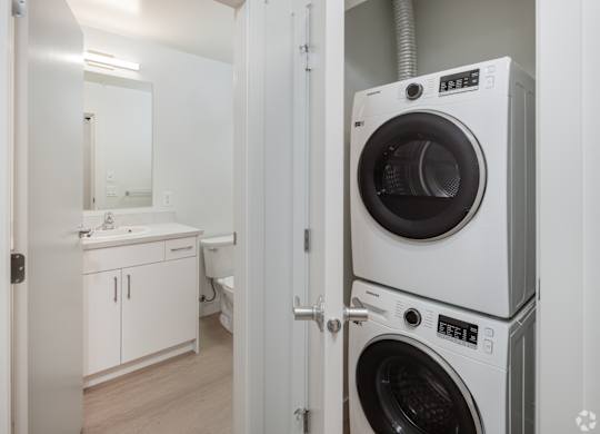 A white washing machine is in a small room.