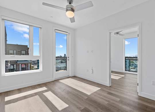Bright empty bedroom with ceiling fan and door to balcony at AMP 30 Apartments, California, 92116