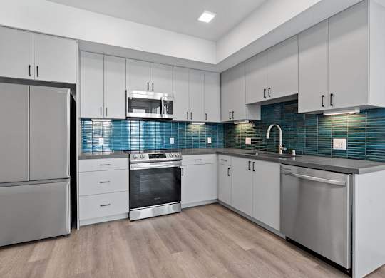 Modern kitchen with blue glass tile backsplash at AMP 30 Apartments, San Diego, 92116