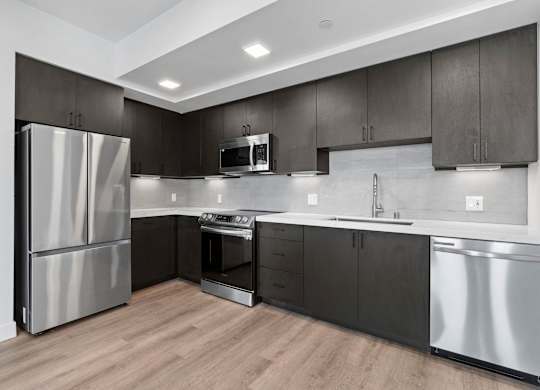 L shaped kitchen with dark wood cabinets at AMP 30 Apartments, San Diego, California