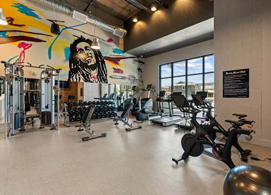 Fitness center with colorful mural and exercise equipment at AMP 30 Apartments, California, 92116