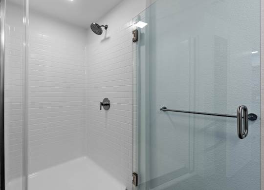 Walk-in shower with white subway tile and glass door at AMP 30 Apartments, San Diego, CA 92116