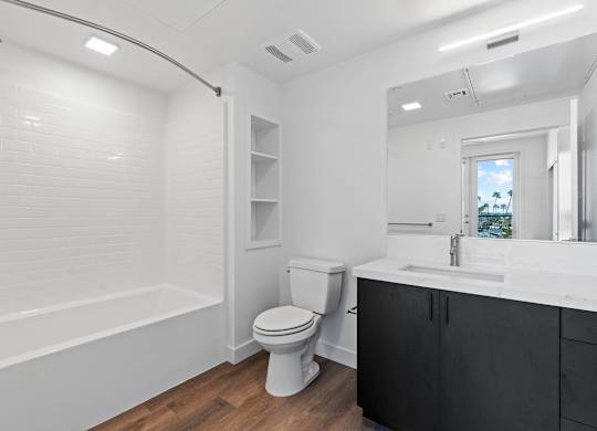 Modern bathroom with white countertop and dark vanity at AMP 30 Apartments, San Diego, CA