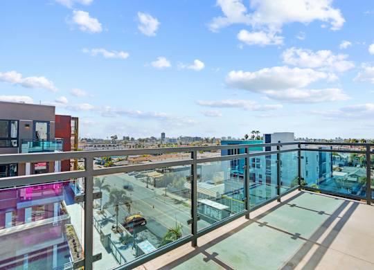 Rooftop deck with glass railing and city views at AMP 30 Apartments, San Diego, CA 92116