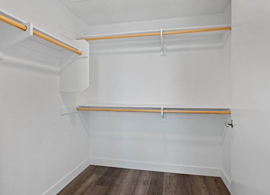 Walk-in closet with wooden hanging rods and shelving at AMP 30 Apartments, California, 92116