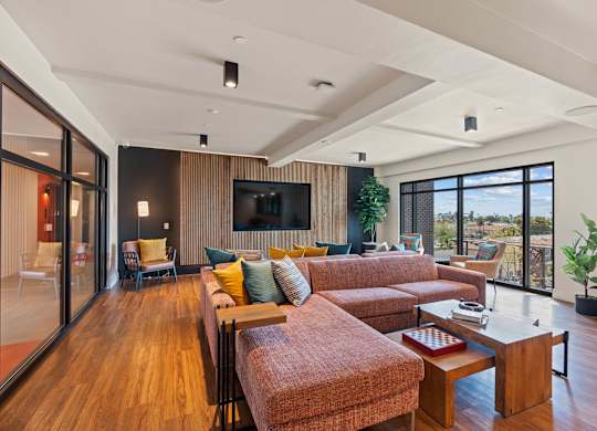 Open concept living room with wood floors and city views at AMP 30 Apartments, San Diego