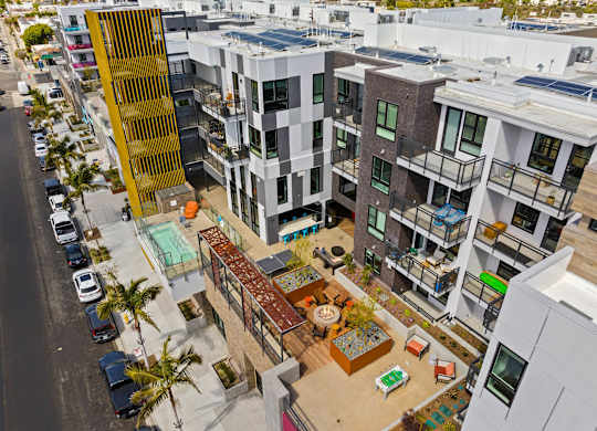Aerial view of courtyard with fire pit and seating at AMP 30 Apartments, San Diego