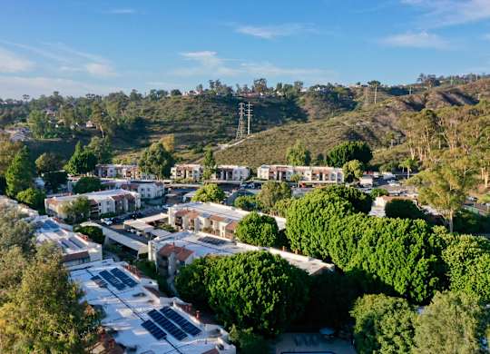 A residential area with houses and solar panels on the roofs.