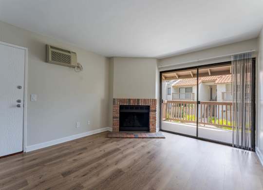 A room with a fireplace and sliding glass doors.