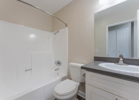A white toilet sits next to a sink in a bathroom.