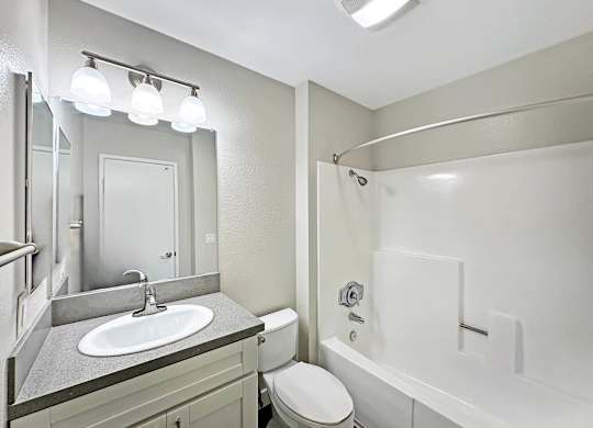 A bathroom with a white toilet, sink, and bathtub.