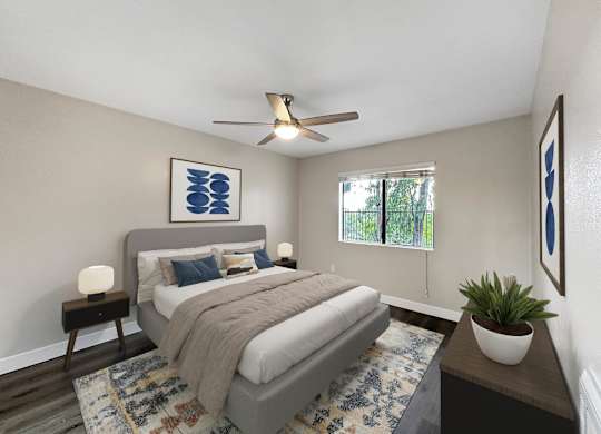 A bedroom with a bed, a ceiling fan, and a rug.