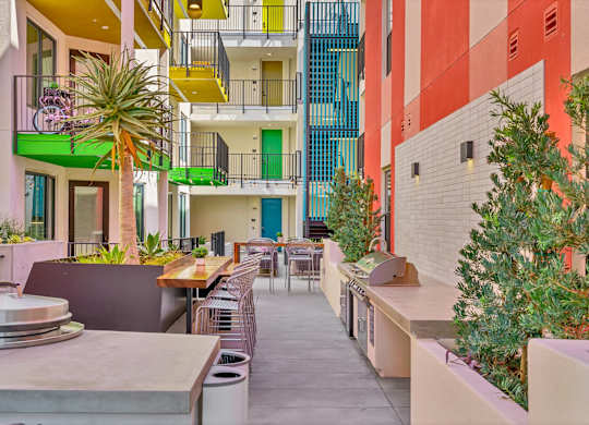 A patio with a table and chairs is surrounded by colorful buildings.