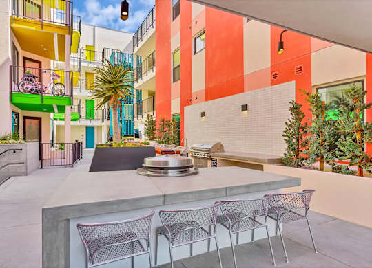 A patio with a table and chairs is surrounded by a colorful building.