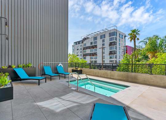 A pool area with a slide and loungers.