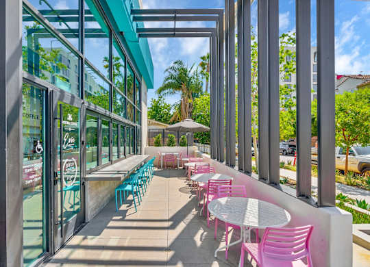 A patio with tables and chairs is covered by a roof.