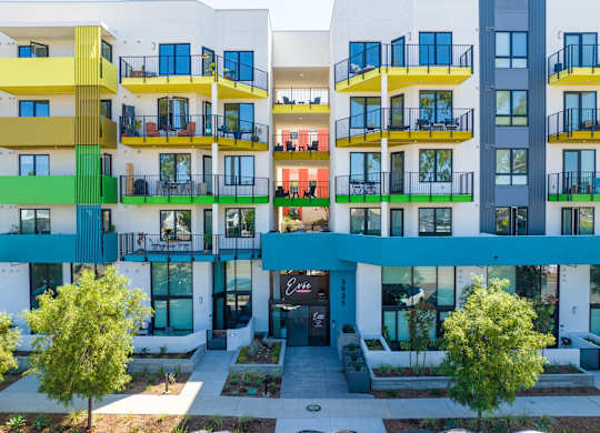 A modern apartment complex with balconies and trees.