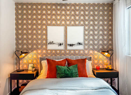 Bedroom with retro patterned wallpaper and orange accents at AMP 30 Apartments, San Diego, California