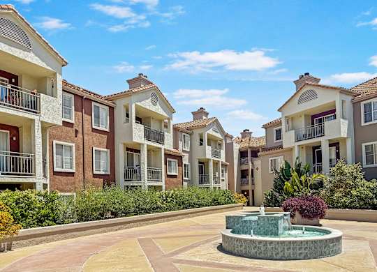 A courtyard with a fountain surrounded by apartment buildings.