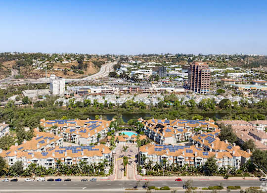 A large housing development with apartment buildings and solar panels on the roofs.