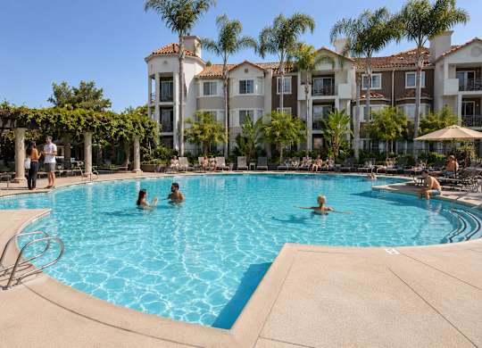 A group of people are enjoying the pool at a resort.