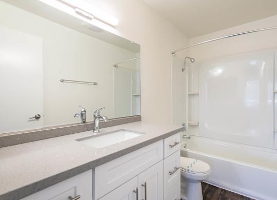 A white bathroom with a sink, toilet, and bathtub.