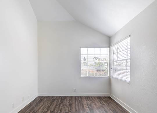 A room with a window and wooden flooring.
