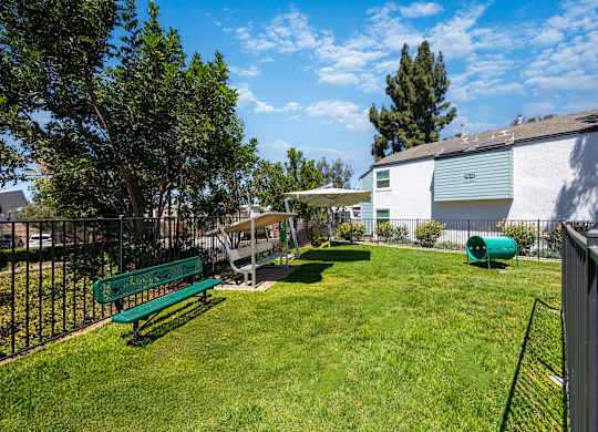 A green bench sits in a grassy yard.