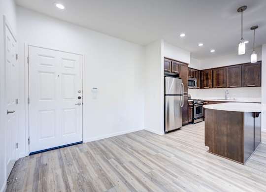 A kitchen with a white door and a white fridge.