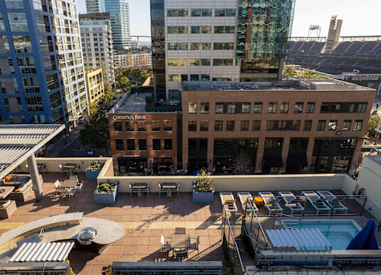 A rooftop patio with a pool and a building with a sign that says