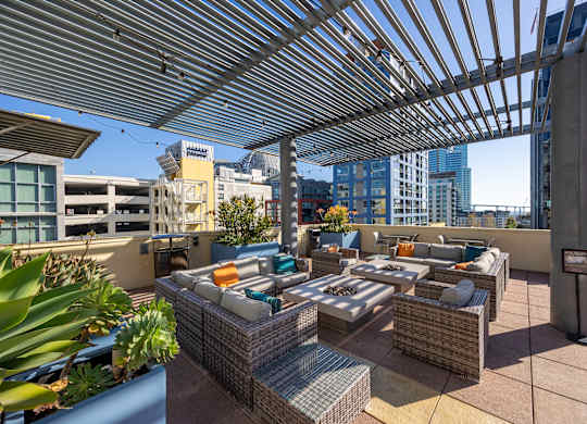 A patio with a table and chairs under a roof.