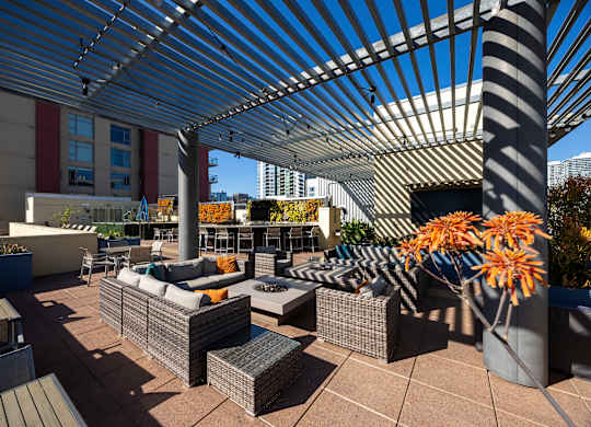 A patio with a white canopy and grey furniture.