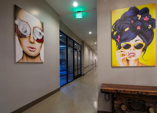 A hallway with two paintings on the wall and a wooden bench.