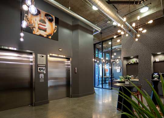 A modern office space with a large poster on the wall and a plant in the corner.
