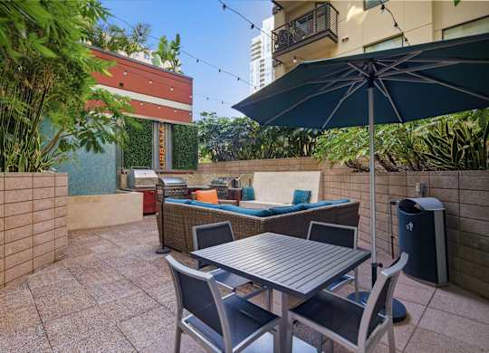 A patio with a table and chairs under an umbrella.