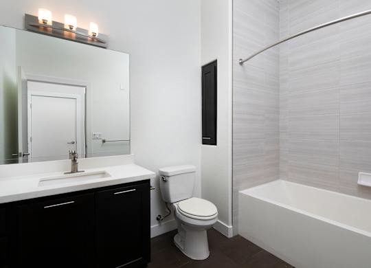 A white toilet sits next to a white sink in a bathroom.