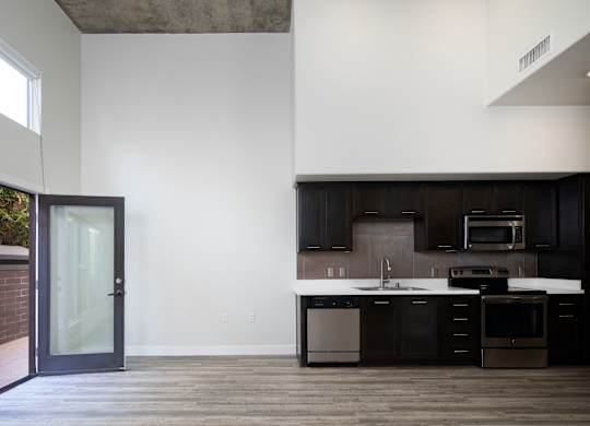 A modern kitchen with dark brown cabinets and a white countertop.