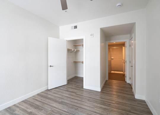 A room with a white door and a grey floor.