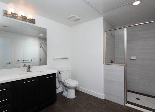 A white bathroom with a toilet, sink, and shower.
