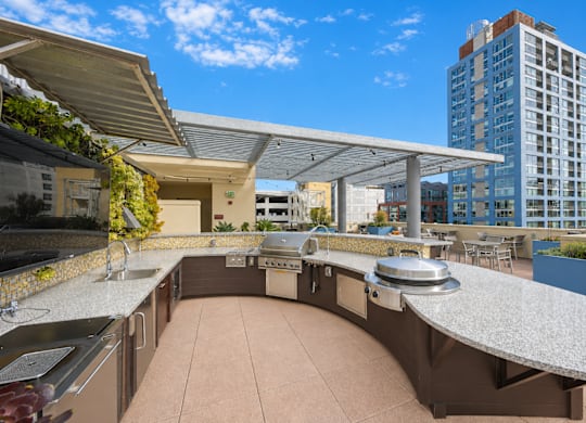 Rooftop outdoor kitchen with curved granite countertop and grill at Urbana Apartments, San Diego, CA